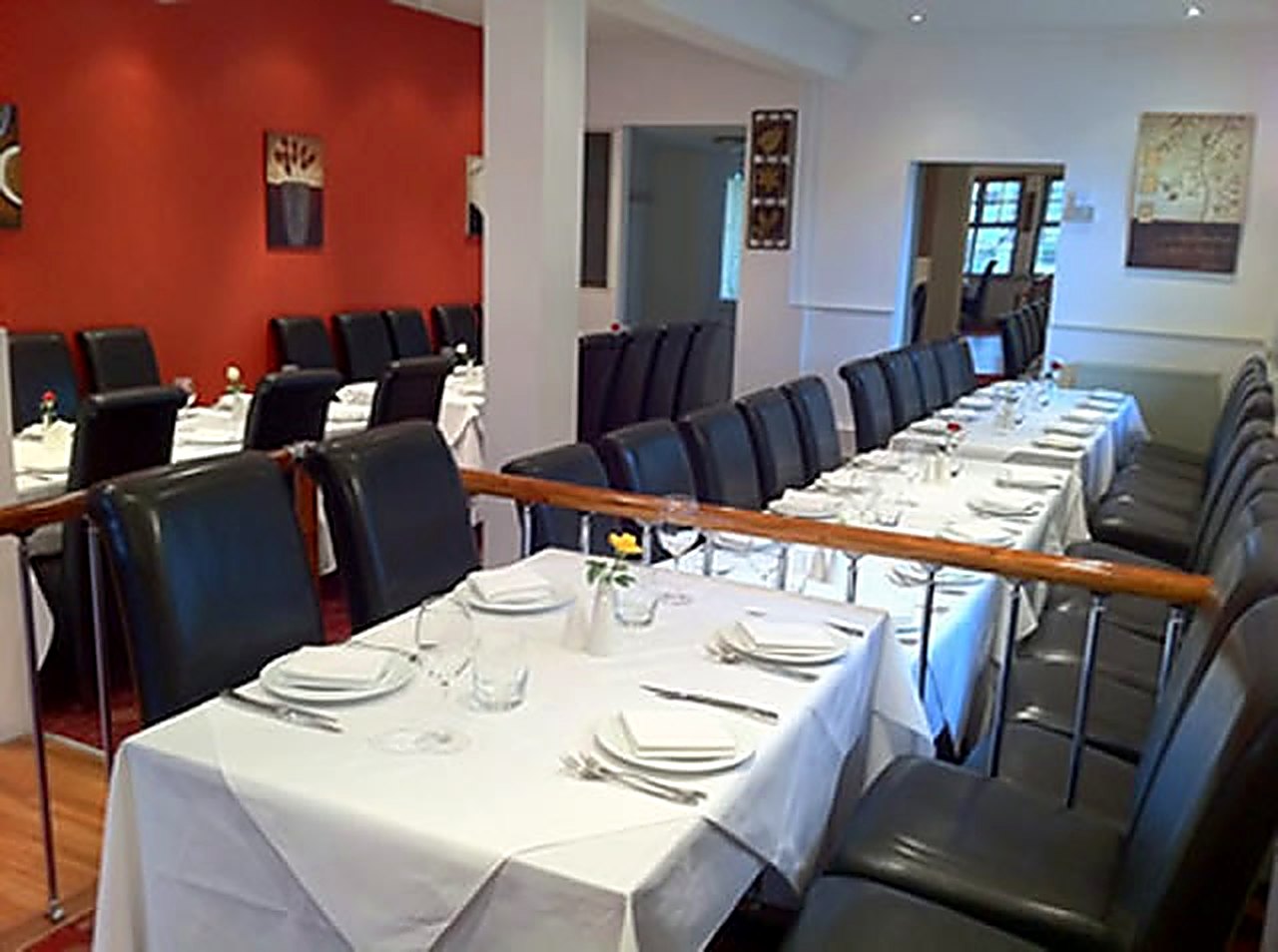 The main dining room laid up for service, with a red feature wall and long tables